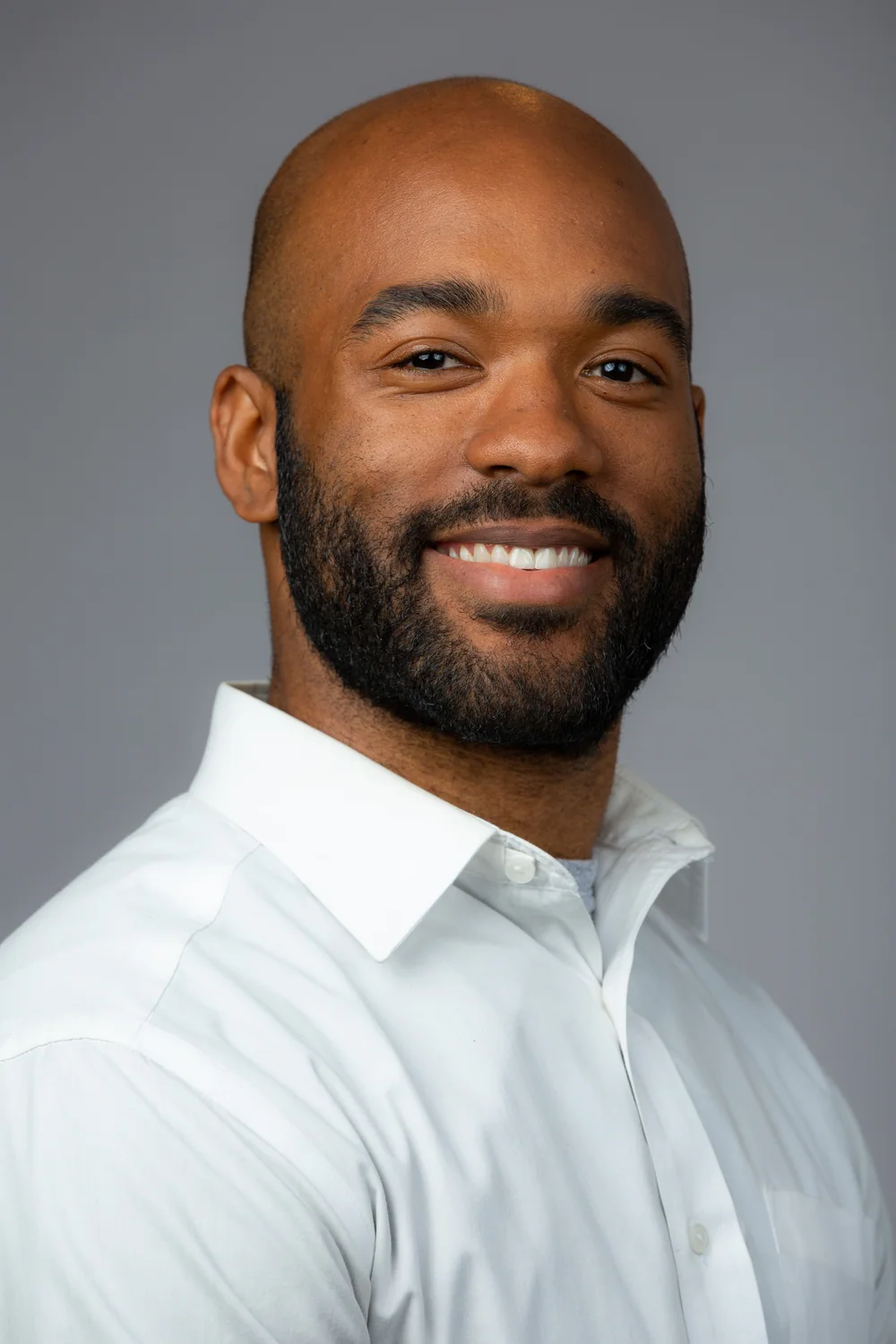 Tyler Allen smiling in a studio portrait.